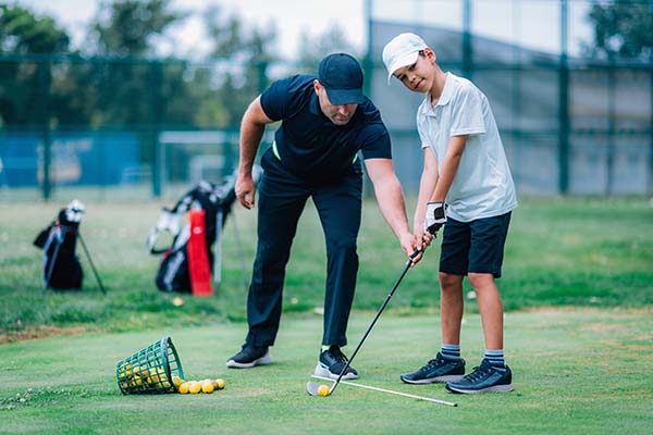 young golfer getting lessons